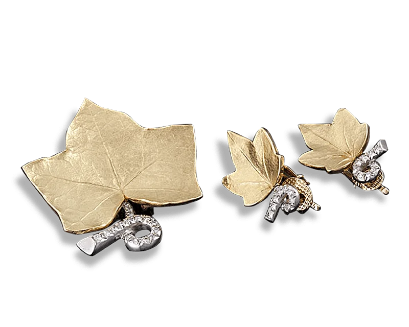 Platinum rings with sparkling sapphire center stones -Cartier Leaf Pin and Earring Suite